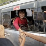 Aung San Suu Kyi is greeted outside a polling station in Kawhmu township