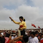 Myanmar pro-democracy leader Aung San Suu Kyi gestures at her supporters to sit down during an entertainment show at a ceremony to mark Myanmar’s New Year Day in her constituency of Kawhmu township
