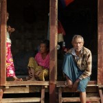 Ethnic Kachin people sit in the doorways of shelters at a temporary camp for people displaced by fighting between government troops and the Kachin Independence Army, or KIA, outside the city of Myitkyina