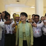 Myanmar pro-democracy leader Aung San Suu Kyi talks to reporters during a break as she attends a parliamentary meeting at the Lower House of Parliament in Naypyitaw