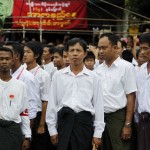 People stand in attention during an event marking the anniversary of Martyrs’ Day at NLD head office in Yangon