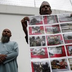 A Rohingya man living in Thailand holds a poster during a protest in front of Myanmar’s embassy in Bangkok