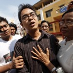 Blogger Latt talks to reporters as his mother and his brother stand beside him after his release, in front of Pa-an prison, in Pa-an