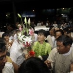 Myanmar pro-democracy leader Aung San Suu Kyi accepts flowers as she arrives at the airport to embark on a trip to the U.S. in Yangon