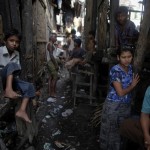 Myanmar Rohingya people pass the time at their slum near the sea in the town of Sittwe