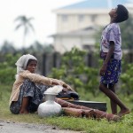 Rohingya Muslims people rest by the road with their belongings as they move from their village after recent violence in Sittwe