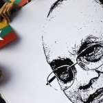 A woman holds a Myanmar national flag and a poster of Myanmar’s President Thein Sein at Yangon International Airport