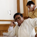 Members of parliament talk on public phones before a parliament meeting in Naypyitaw