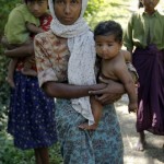 The wife of Tun Naing, a Rohingya Muslim man, holds one of their children in Paik Thay
