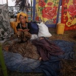 A woman displaced by the recent violence in Pauktaw sits by her sleeping child at Owntaw refugee camp for Muslims outside Sittwe