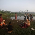 People displaced by the recent violence in Pauktaw wash clothes by a pond near Owntaw refugee camp for Muslims outside Sittwe