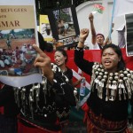 A group of native Kachin living in Thailand hold banners and shout slogans as they protest in front of Myanmar’s embassy in Bangkok