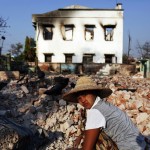 A woman collects bricks and other useful items from burnt Muslim homes in Meikhtila