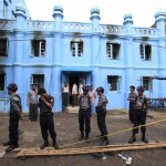 Police stand in front of a mosque and school dormitory that were damaged by a fire in Yangon