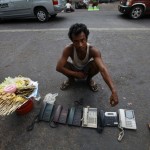 A man sells used phones on a street in Yangon