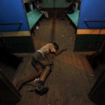 A disabled man sleeps on the floor of a train carriage in Yangon