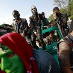 Young men sit on a vehicle as they celebrate the Myanmar New Year Water Festival   in Yangon