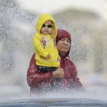 Man carries girl as they get sprayed with water during Myanmar’s New Year Water Festival in Yangon