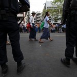 People gather near a mosque that was damaged in a fire in Yangon