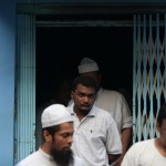 Muslim men exit a mosque that was damaged by a fire in Yangon