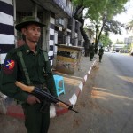 Soldiers stand guard on the side of a street in Meikhtila