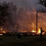 A-man-looks-at-buildings-on-fire-during-riots-at-Oakkan-village-north-of-Yangon