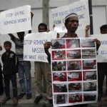 Rohingya people living in Thailand hold posters and signs as they protest in front of Myanmar’s embassy in Bangkok
