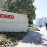 Men look at the logo of Qatar Telecom Ooredoo (Reuters)