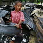 A boy salvages belongings amid burnt debris at Htan Kone village in Myanmar’s northern Sagaing region