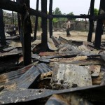 A man walks near burnt houses at Htan Kone village in Myanmar’s northern Sagaing region