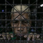 A Rohingya Muslim illegal immigrant looks out from the Immigration Detention Centre during Ramadan in Kanchanaburi
