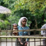 Rohingya Muslims stand near their home in Ohntawgyi village, outside of Sittwe