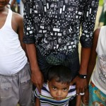 Rohingya Muslims stand near their home in Ohntawgyi village, outside of Sittwe