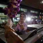 Myanmar’s opposition leader Aung San Suu Kyi receives flowers from supporters as she arrives home from a trip to Europe, at Yangon International Airport