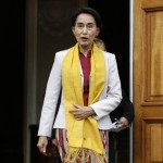 Myanmar’s opposition leader Suu Kyi reacts after seeing photographers waiting for her after her meeting with Poland’s former president Walesa in Warsaw