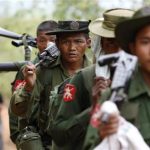 Army soldiers carry weapons as they walk to the earthquake struck area in Tarlay