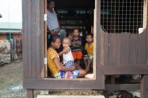 A family in the Myaing Thar Yar resettlement village, built by the Burma government as compensation for displacing villagers that used to own land in the new SEZ in Thilawa.  Some of the villagers have become activists, calling for larger compensation for the loss of their land and their previous lifestyle. June 2014. (Photo: DVB/ C.I.Smith)