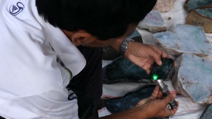 A potential buyer examines a piece of jade at Naypyidaw's gem emporium. (PHOTO: DVB).