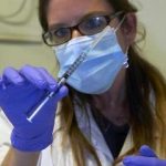 A nurse holds a syringe containing an experimental Ebola vaccine during a media visit at the CHUV in Lausanne