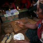 A miner barters his jade stone for heroin at a heroin shop near a mine dump in Hpakant jade mine at Kachin state