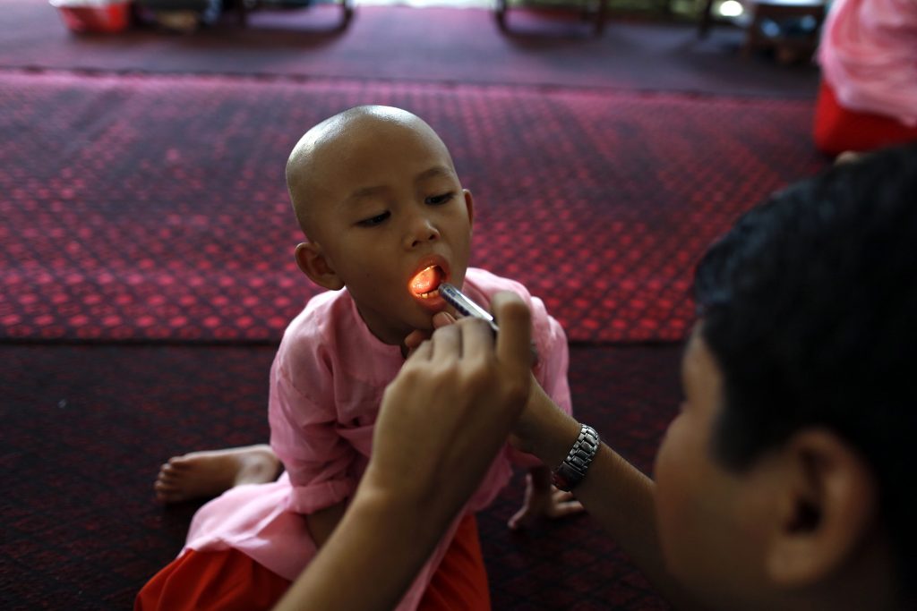 A doctor examines a Buddhist novice nun in the Healthy Farm charity clinic at a monastery outside Rangoon November 2, 2013. PHOTO: Reuters