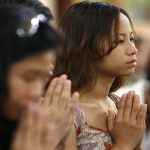 People attend a prayer meeting for the victims of Cyclone Nargis at the Burmese Buddhist Temple in Singapore