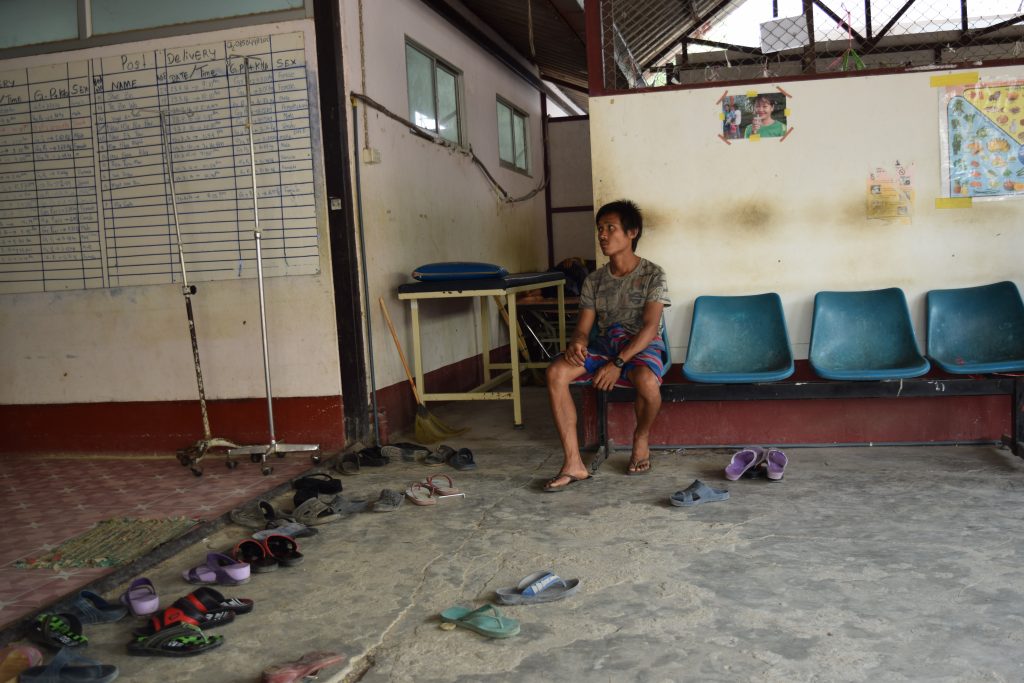 A man waits outside the recovery room for his partner. 