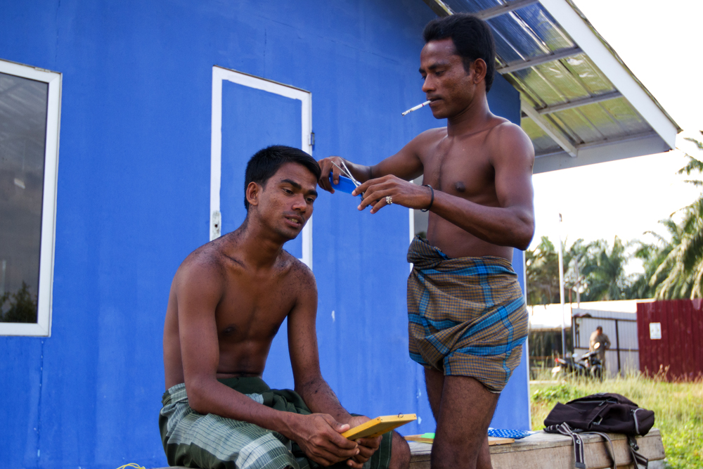 A Rohingya refugee gives another a haircut at Bayeun Refugee Camp, in the outskirts of Langsa City (Aceh Province, Indonesia). Photo: Carlos Sardiña Galache / Yayasan Geutanyoe – A Foundation for Aceh.