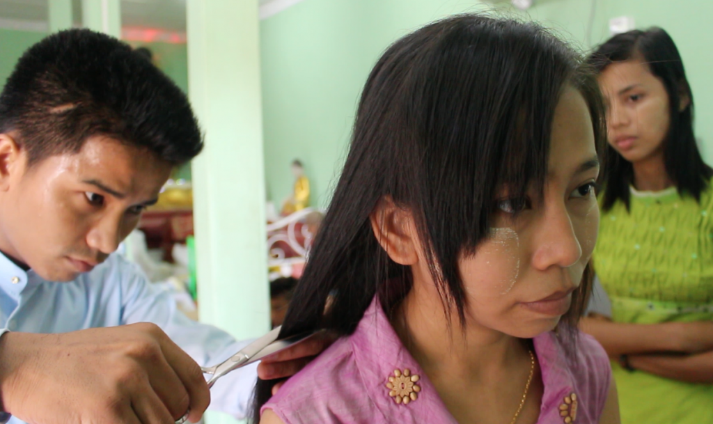 A lady cuts her hair to donate to the 'Gold Hair bridge' project. (Photo: Libby Hogan / DVB)