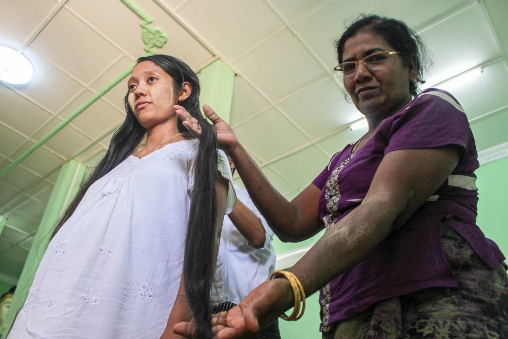 25 year-old Myo Myo Aung gets ready to cut off her long hair and donate it to the “Gold Hair Bridge” project. (Photo: Libby Hogan / DVB)