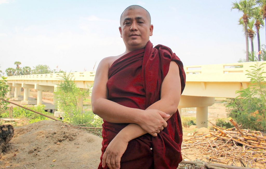 Sayadaw U Weiponla stands at the largest bridge built thanks to hair donations and private donations. (Photo: Libby Hogan / DVB) 