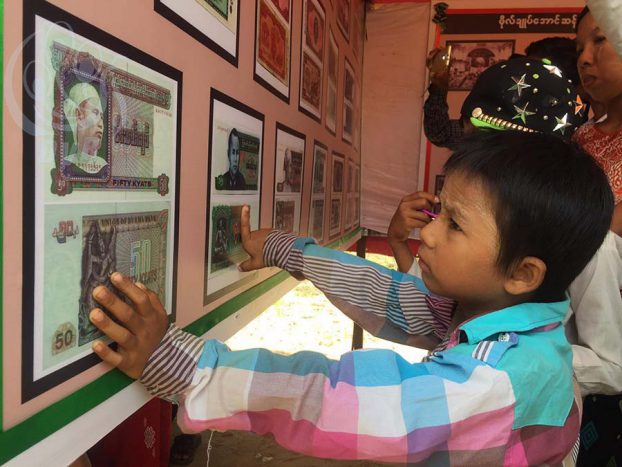 A boy looks at Burmese banknotes bearing portraits of Aung San at a museum honouring Burma's independence hero in his hometown of Natmauk, Magway Division, on 19 July 2016. (Photo: DVB) 