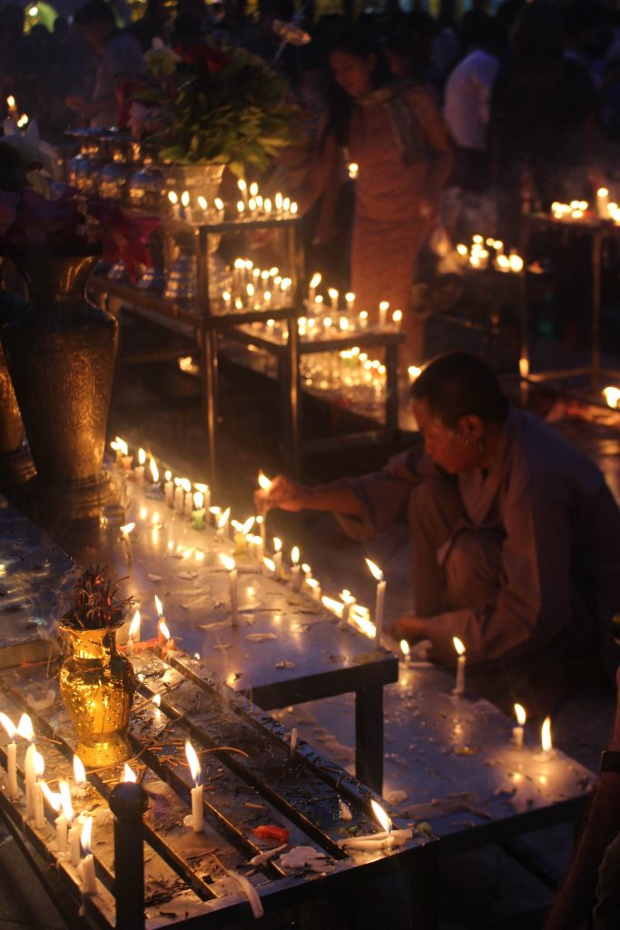 A man surrounded by candles. (Photo: Libby Hogan / DVB)