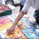 A-customer-sifts-through-SIM-cards-at-a-vendors-table-in-Yangon-Credit-DVB